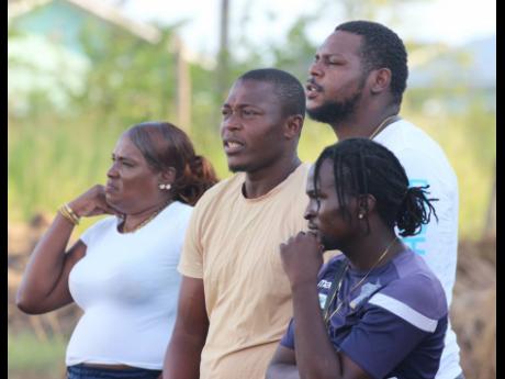 Waterhouse and national goalkeeper Kemar Foster (second left) among spectators watching the ISSA Manning Cup encounter between Innswood High and Mona High at Chedwin Park last Friday.
