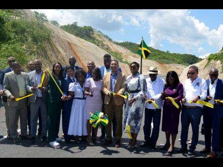 Prime Minister Andrew Holness (centre), along with members of his Cabinet and other stakeholders, cuts the ribbon to officially open the May Pen to Williamsfield leg of the south coast highway.