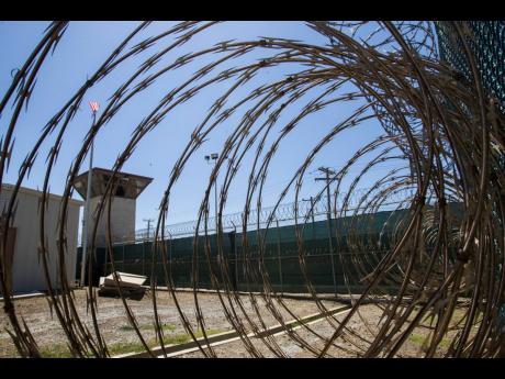 In this April 17, 2019, photo, reviewed by US military officials, the control tower is seen through the razor wire inside the Camp VI detention facility in Guantanamo Bay Naval Base, Cuba. A military medical panel has concluded that one of the five 9/11 de