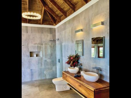 A floor-to-ceiling porcelain-clad bathroom with twin vessel vanity sinks.