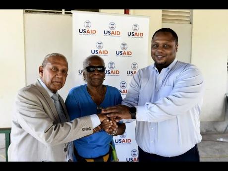 May Pen Mayor Winston Maragh (left) greets Dr Deanna Ashley (centre), executive director of the VPA, and Gerard Fontain, director, Office of Citizen Security at USAID Jamaica. They were at the sports and family fun day in observation of International Day o