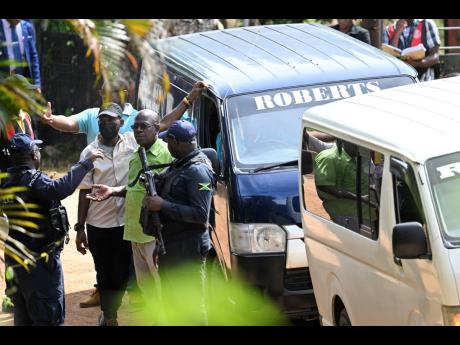 Police personnel in discussion with employees from Roberts Funeral Home at the scene. 