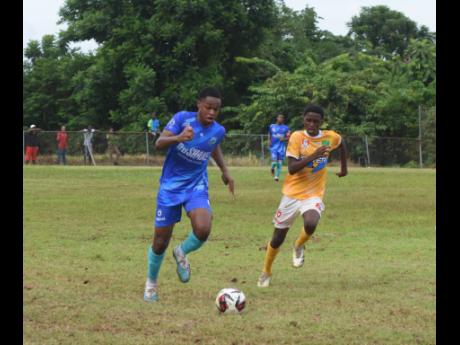 Credit: Ashley Anguin The Manning’s School’s Omar Seville (left) chases a ball ahead of Knockalva’s John Brown during an ISSA/WATA daCosta Cup game at the Knockalva Sports Complex in Hanover on Tuesday.