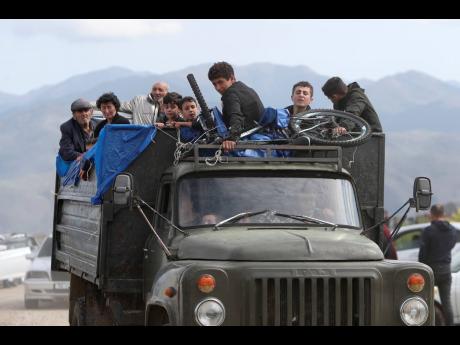 Ethnic Armenians from Nagorno-Karabakh travel on a truck on their way to Kornidzor, Armenia.