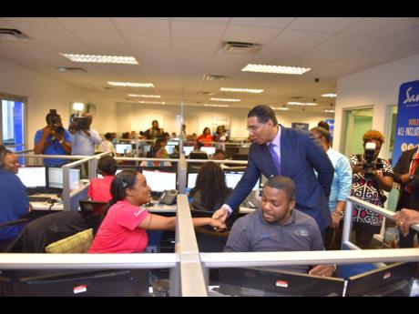 Prime Minister Andrew Holness greets employees of a business process outsourcing centre during a recent visit.