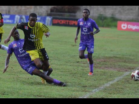 Kingston College’s Deshawn Byfield (left) tackles Michael Emmanuel of Charlie Smith High during a Manning Cup match at Calabar High on Wednesday, September 27. Kingston College won 1-0.