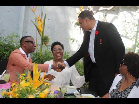 Prime Minister Andrew Holness greets Michael Henlin, husband of attorney-at-law M. Georgia Gibson Henlin (centre). 