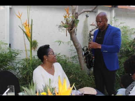 Attorney-at-law M. Georgia Gibson Henlin listens as saxophonist Verlando Small moves her with a rendition of ‘Do you Know that You are my Hero’.