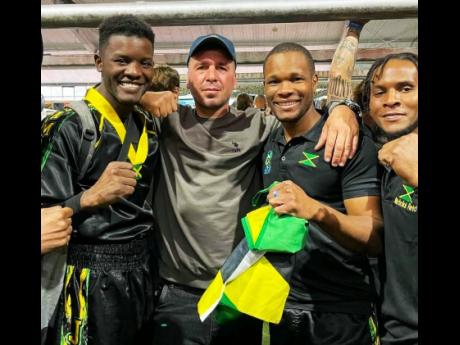 Jamaican fighters Richard Stone (left), Nicholas Dusard (third left) and Nicholai Reid (right) are joined by a fan while basking in their eight-medal haul at the October 18-22 International Sport Kickboxing Association’s Amateur Members Association World