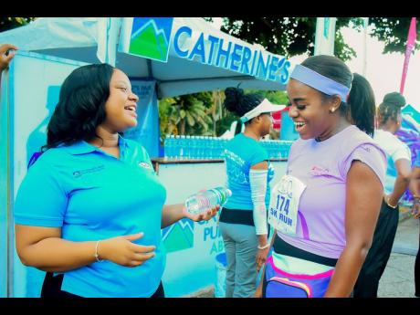 Catherine’s Peak and Grace Foods senior brand representative Breanna Golding (left) engages with Danielle Reynolds after she crossed the finish line to complete the CIBC FirstCaribbean ‘Walk for the Cure’ 5K. The fundraising charity event, which was 