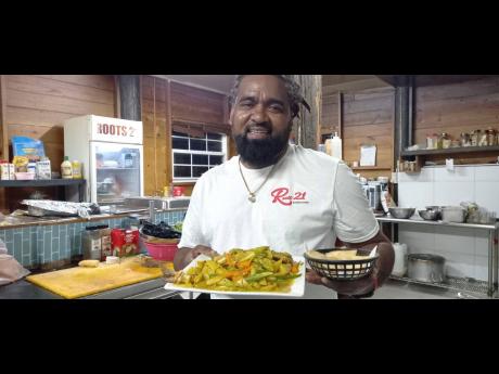 Portland businessman Peter Hall showing off a curried fish meal prepared by him.