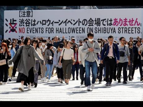 A giant public notice board from Shibuya district, which reads “No Events for Halloween on Shibuya Streets” is seen at the Shibuya pedestrian crossing in Tokyo.
