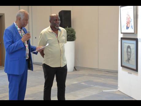 Dr. Brian Morgan (at left) admires studies of the singer Jimmy Cliff with its author, artist Joshua Higgins