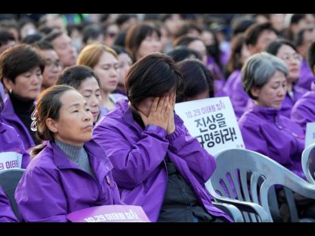 A family member of a victim weeps during a rally to mark the first anniversary of the harrowing crowd surge that killed about 160 people in a Seoul alleyway, at the Seoul Plaza.