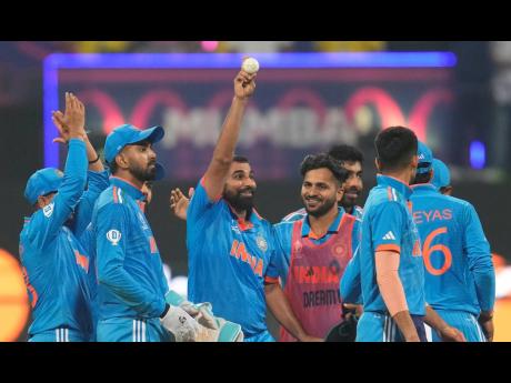 Credit: AP India’s Mohammed Shami (centre) holds the ball as he celebrates his five-wicket haul after dismissing Sri Lanka’s Kasun Rajitha during the ICC Men’s Cricket World Cup match between India and Sri Lanka in Mumbai, India yesterday.