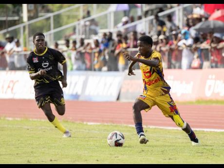 
St Andrew Technical High School’s Kevin Hall (right) dribbles by Kingston Technical High School’s Nockoy Walters during an ISSA/Digicel Manning Cup game at the Ashenheim Stadium earlier this week.