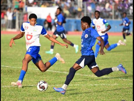 Hydel’s Michael Forbes tries to stop the advances of Jamaica College’s Amarlie King during their ISSA/Digicel Manning Cup clash at the Ashenheim Stadium yesterday.