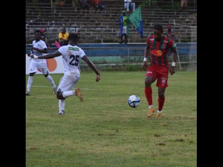  Montego Bay United’s Nevaun Turner (right) powers past Jalmaro Calvin of Cavalier during yesterday’s  Wray and Nephew Jamaica Premier League match at  WesPow Park in Tucker, St. James. Montego Bay United won 1-0.
