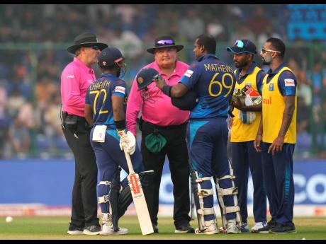 Sri Lanka’s Angelo Mathews (centre) argues with umpires after he was declared timed out during the ICC Men’s Cricket World Cup match between Bangladesh and Sri Lanka in New Delhi, India yesterday. Mathews who wasn’t ready to face his first ball withi