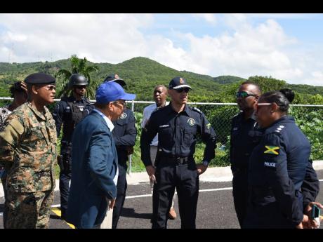 National Security Minister Dr Horace Chang (third left) and Police Commissioner Major General Antony Anderson (third right) and members of the Jamaica Constabulary Force and Jamaica Defence Force visiting the volatile Salt Spring community in St James on T
