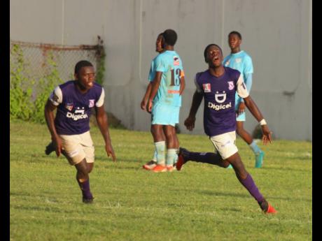 Kingston College’s goalscorer Alex Hislop (right) celebrates after scoring in stoppage time during their 2-1 loss to St Catherine High in their ISSA/Manning Cup quarter final encounter at the  Spanish Town Prison Oval yesterday.