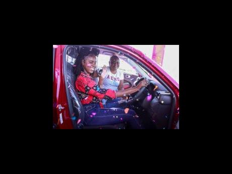 Martena Dawkins and her mom, Janine Hibbert, are showered in confetti as they enjoy the feel of their brand new 2023 Honda HRV at the Hot Summer Wheels handover last Friday at the Seprod Group of Companies. 