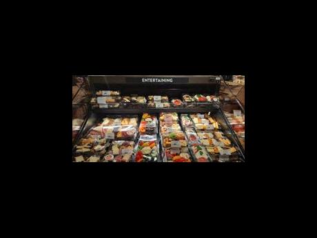 A beautiful array of vegetables, fruits and charcuterie packages on display. 