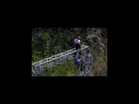 Workers restore power lines damaged by Hurricane Maria in Barceloneta, Puerto Rico in October 2017.
