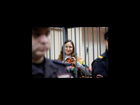 Sasha Skochilenko, a 33-year-old musician, shows a heart behind bars in the courtroom as she waits for a hearing in the Vasileostrovsky district court in St Petersburg, Russia.