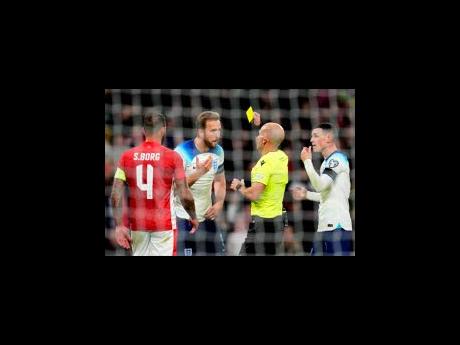 Referee Luis Godinho shows a yellow card to England’s Harry Kane (second left)  during the Euro 2024 Group C qualifying  match between England and Malta at Wembley stadium in London yesterday.