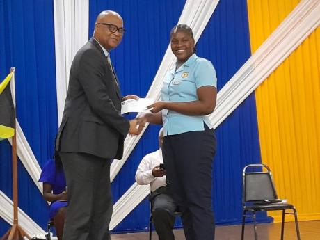 Credit: Contributed Cavina Atkinson, secretary to the Guild of Students, receiving a scholarship from the Moneague College principal, Howard Isaacs.