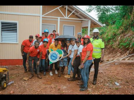 Following a successful day’s work, the Red Stripe and Food For The Poor Jamaica (FFPJ) teams joined Manchester resident, Meghan Swaby for a photo op at the entrance of her new home. Red Stripe partnered with FFPJ to build the first of five houses as part