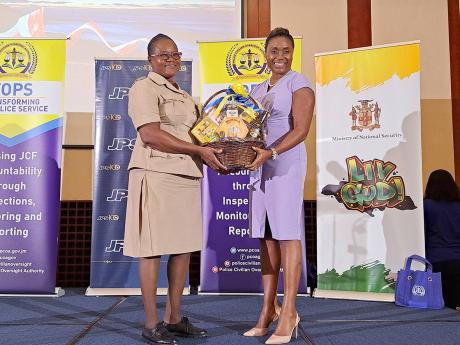 Credit: Christopher Thomas Inspector Shawn Whyte (left), custody officer at the Freeport Police Station in Montego Bay, St James, receives an award on behalf of the Freeport station from Juliet Cuthbert-Flynn, state minister in the Ministry of National Security, during Wednesday’s