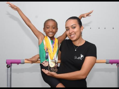 Seven-year-old gymnast, Joelle Williams, takes a photo with her mother, Racquel Fray-Williams at their home on Monday November 6.
