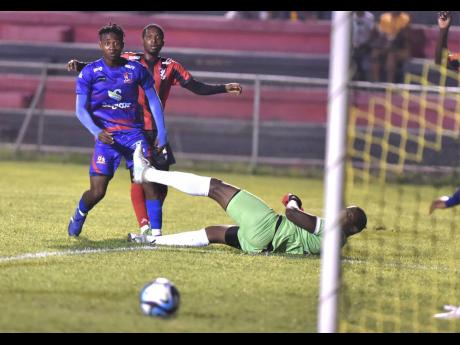 Nicholas Nunes/Photographer 
Dunbeholden’s Zackia Wilks (left) wand Arnett Gardens’ Rushike Kelson look on as a ball goes past the post Dunbeholden goalkeeper Damian Hyatt during a Jamaica Premier League match at the Anthony Spaulding Sports Complex la