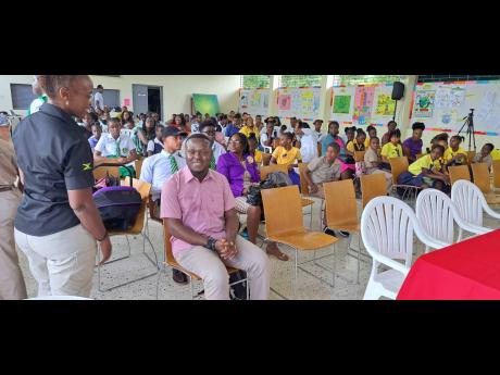 Odane Brooks, CARICOM youth ambassador, seated among students.