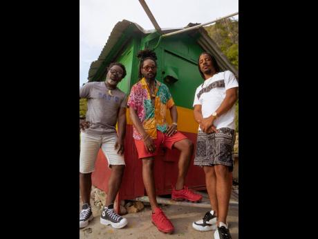 Kabaka Pyramid is flanked by members of Dukes of Roots.