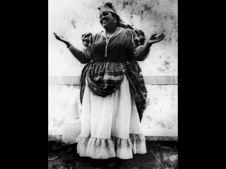 Miss Lou performing in her bandana costume which is an undeniable part of Jamaican heritage.