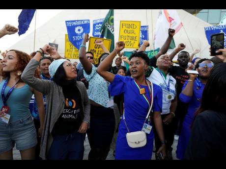 Activists participate in a demonstration for the Loss and Damage Fund at the COP28 UN Climate Summit in Dubai, United Arab Emirates, on Wednesday.