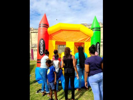 Students of the Montego Bay Learning Centre lining up to use the bounce-about during a Christmas treat held last Wednesday.