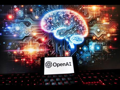 The OpenAI logo is displayed on a cell phone with an image on a computer monitor generated by ChatGPT’s Dall-E text-to-image model on Friday in Boston.