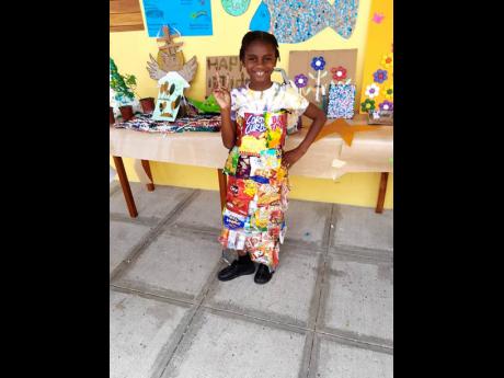  Grace Sterling, grade-three student at Savanna-la-Mar Inclusive Academy (Sav Inclusive), poses for the camera wearing a dress made from used snack bags at the school’s Eco Champions Day event held on Tuesday.
