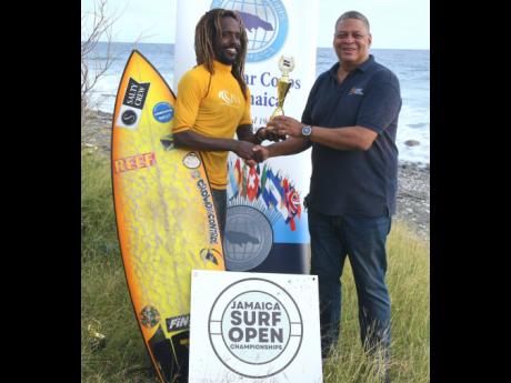 Jamaica Surfing Championships’ men’s division winner Icah Wilmot (left) accepts his trophy from Robert Scott, second  vice-president of the Jamaica Olympic Association, following the event which was held on Saturday at Makka Beach in St Thomas.