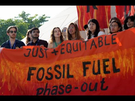 Mitzi Jonelle Tan of the Philippines (centre) gets emotional while participating in a demonstration against fossil fuels at the COP28 UN Climate Summit,  on December 13 in Dubai, United Arab Emirates. 