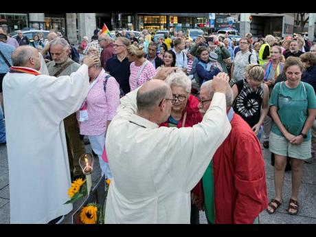 Married and same-sex couples take part in a public blessing ceremony in front of the Cologne Cathedral in Cologne, Germany in September. Pope Francis has formally approved allowing priests to bless same-sex couples, with a new document released yesterday e