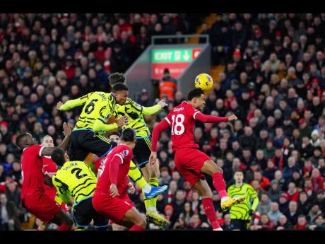 
Arsenal’s Gabriel (top left) heads the ball to score his side’s opening goal during an English Premier League match against Liverpool at Anfield stadium in Liverpool, England, yesterday.