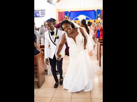 Credit: Contributed Newly wedded, Danaia (right) and Jahzeal Clarke make their way down the aisle.