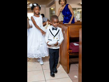 Credit: Contributed Flower girl Jahzealina (left) assists her little brother Jahzeal Jr as he makes his way down the aisle.