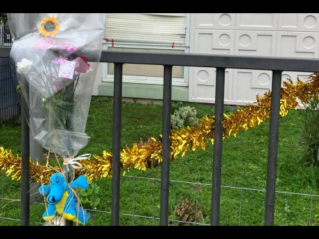 Flowers lay at the gate where four children and their mother were found killed in Meaux, east of Paris, on Christmas day. 