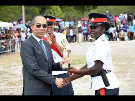 Dr Horace Chang (left), minister of national security, presents the award for ‘Highest Mark Obtained’ to Woman Constable Donique Anderson (right) while Sergeant Marguerite Gardner looks on during the Passing-Out Parade and Awards ceremony at the Nation